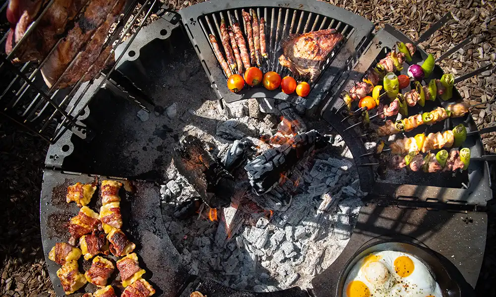 Ansicht von oben auf den Modulgrill und sechs verschiedenen Grillmodulen, die reichlich mit Fleisch und Gemüse belegt sind