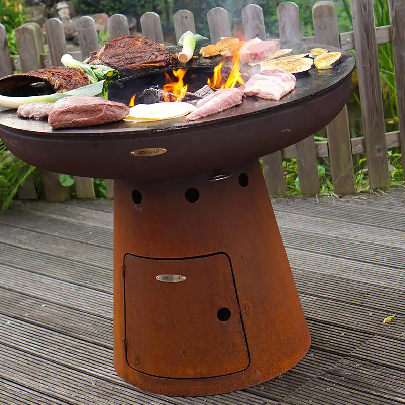 Voll belegte Feuerstelle Nero mit verschiedenem Grillgut auf einer Terrasse