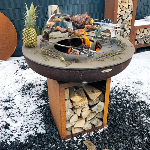Remundi Feuerstelle mit Grillbrücke, die mit Grillgut belegt ist