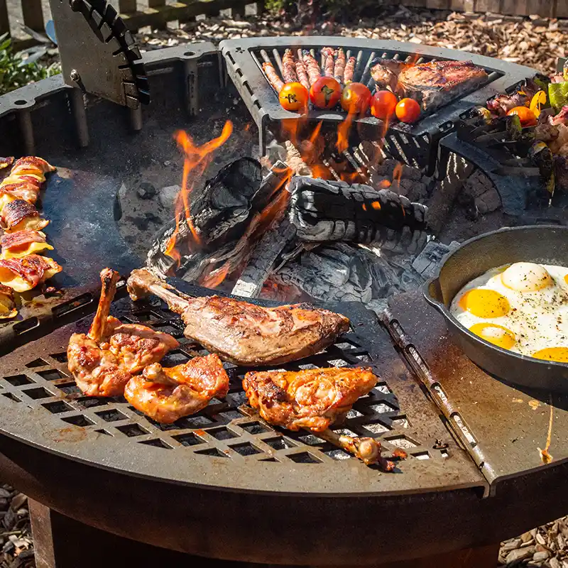 Modulgrill mit sechs verschiedenen Grillmodulen, die einen Ring ergeben und mit Fleisch und Gemüse belegt sind