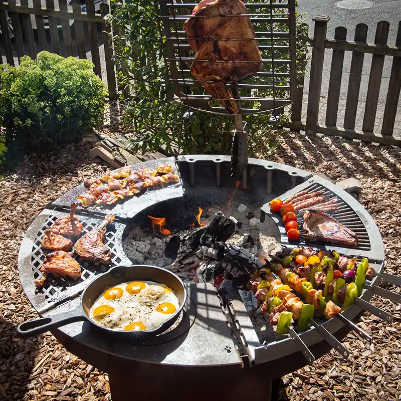 Modulgrill mit sechs verschiedenen Grillmodulen, die einen Ring ergeben und mit Fleisch und Gemüse belegt sind