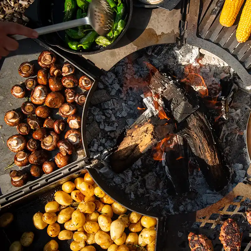 Ansicht von oben auf den Modulgrill und sechs verschiedenen Grillmodulen, die reichlich mit Fleisch und Gemüse belegt sind