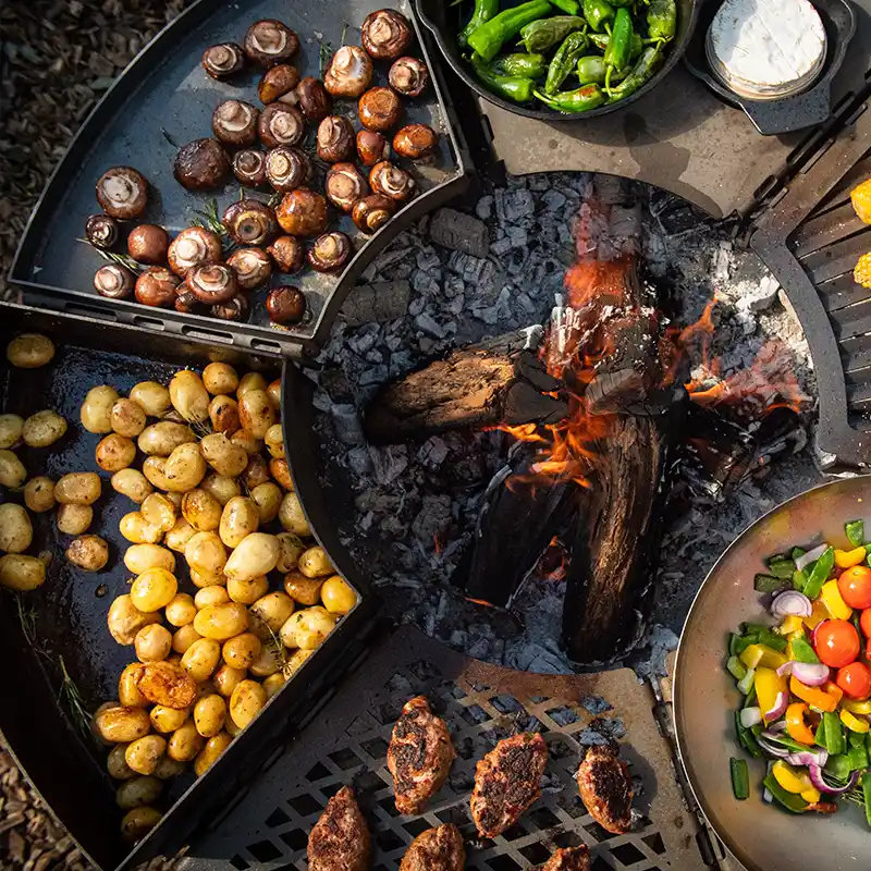 Ansicht von oben auf den Modulgrill und sechs verschiedenen Grillmodulen, die reichlich mit Fleisch und Gemüse belegt sind