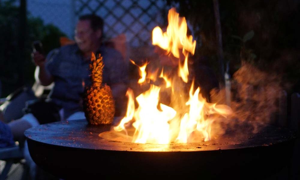Remundi Feuerstelle im Garten als Design-Objekt. Der massive Stahl in edler Rost-Optik (Corten) wirkt tagsüber als moderne Skulptur und abends als Wärmequelle.