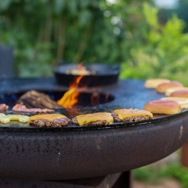 smashed burger platter three smashed burger patties lie on the edge of the Remundi fire bowl with grill and are kept warm