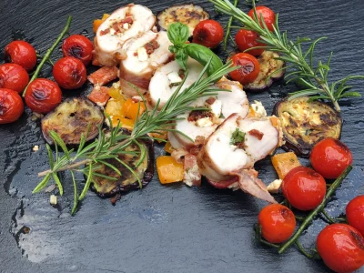 Mit Feta gefüllte Hähnchenbrust in Bacon auf der Remundi Feuerplatte mit Paprikagemüse und Aubergine