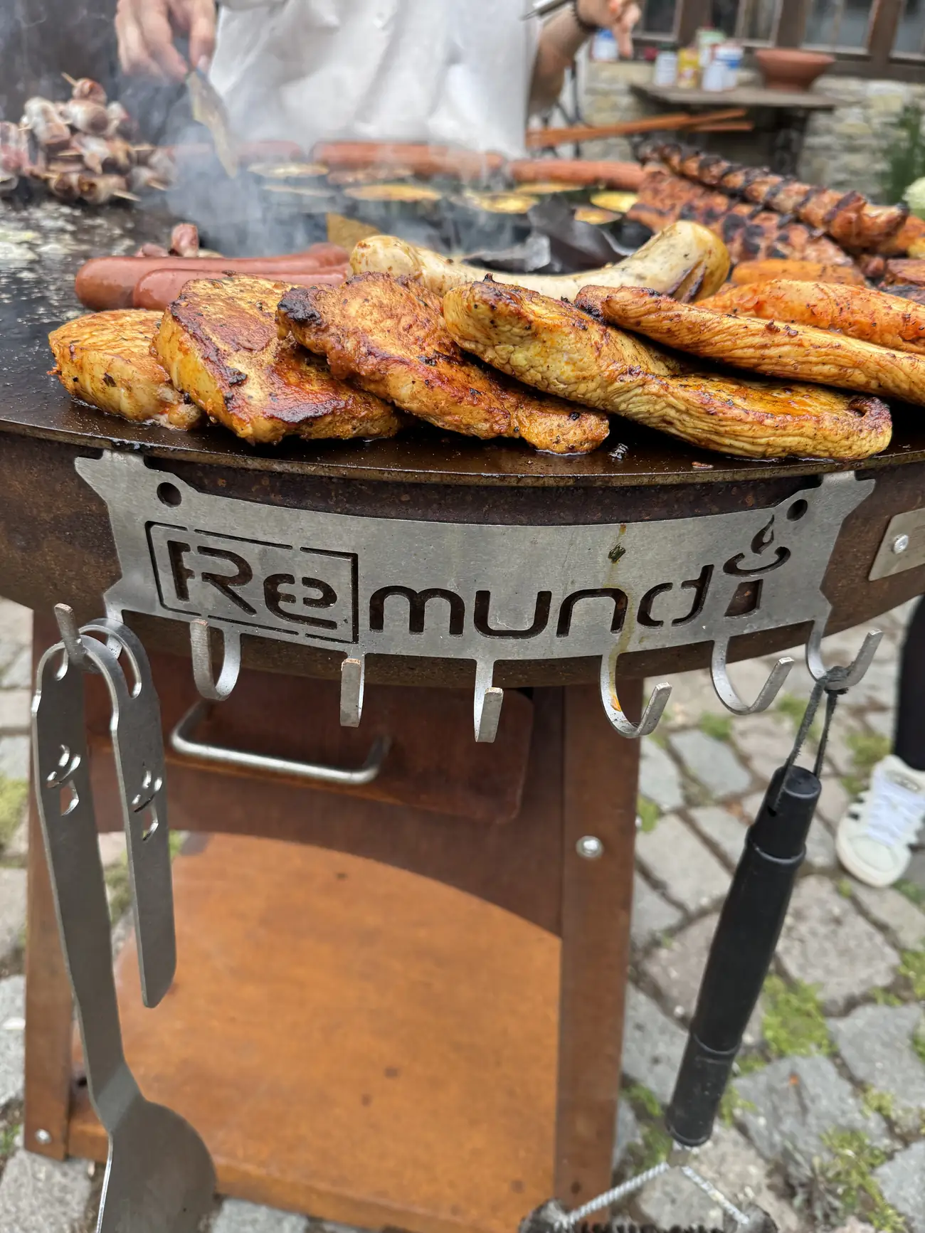 Grillgut ruht am äußeren Rand der Remundi Feuerplatte